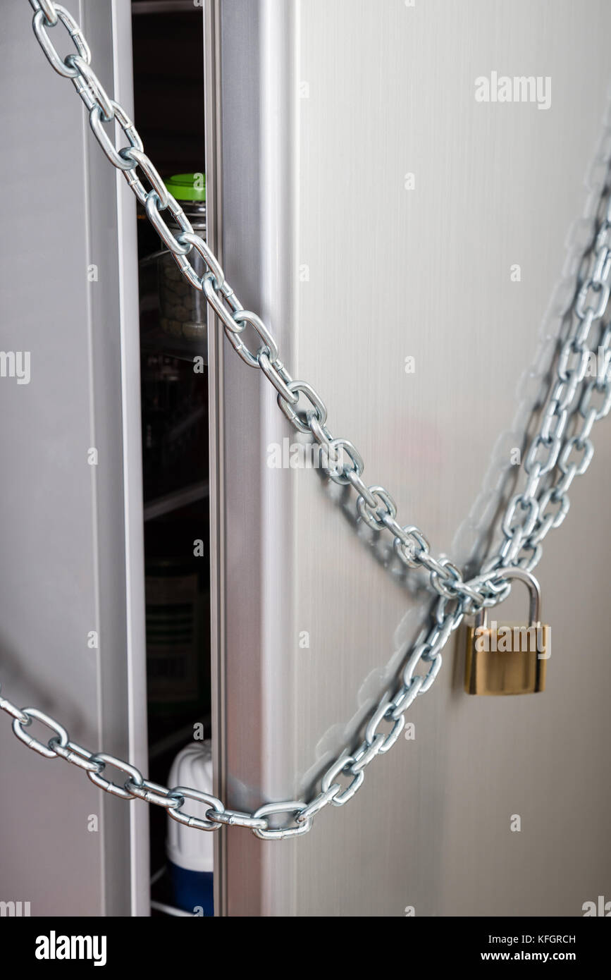 Primer plano del refrigerador bloqueado con cadena y candado Fotografía de  stock - Alamy
