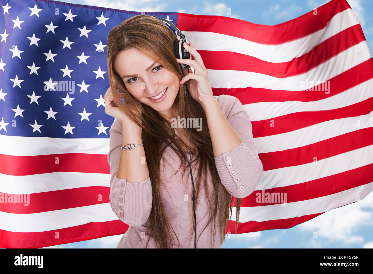Mujer escuchando audiolibros curso de aprendizaje del idioma inglés en  frente de la bandera americana Fotografía de stock - Alamy