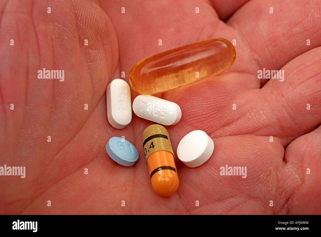 La dosis diaria de pastillas en la mano del anciano Foto de stock