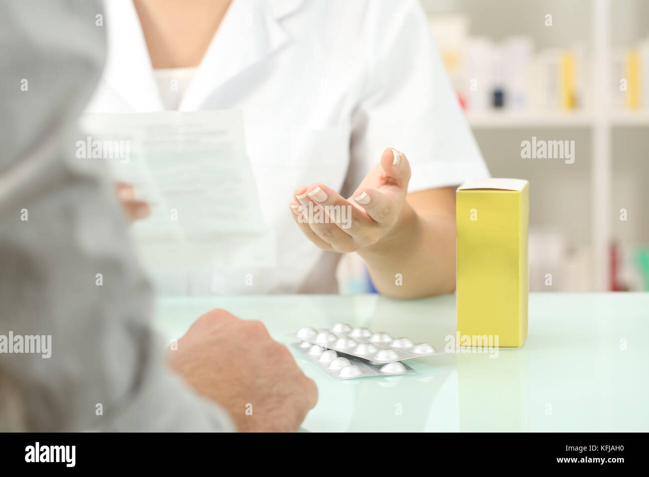 Cierre de un farmacéutico leer el prospecto de un medicamento a un paciente en una farmacia para interiores Foto de stock