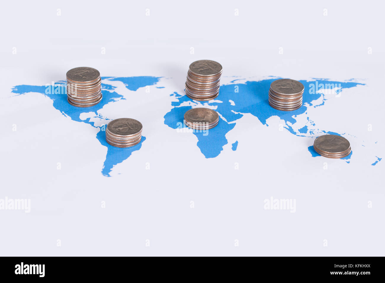 Concepto de negocio global. Pila de monedas en el mapa del mundo Foto de stock