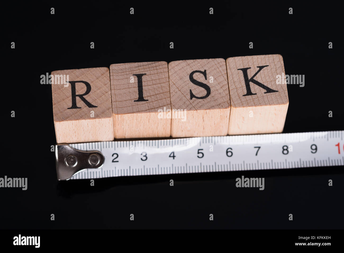 Medir riesgos con regla sobre fondo negro Foto de stock