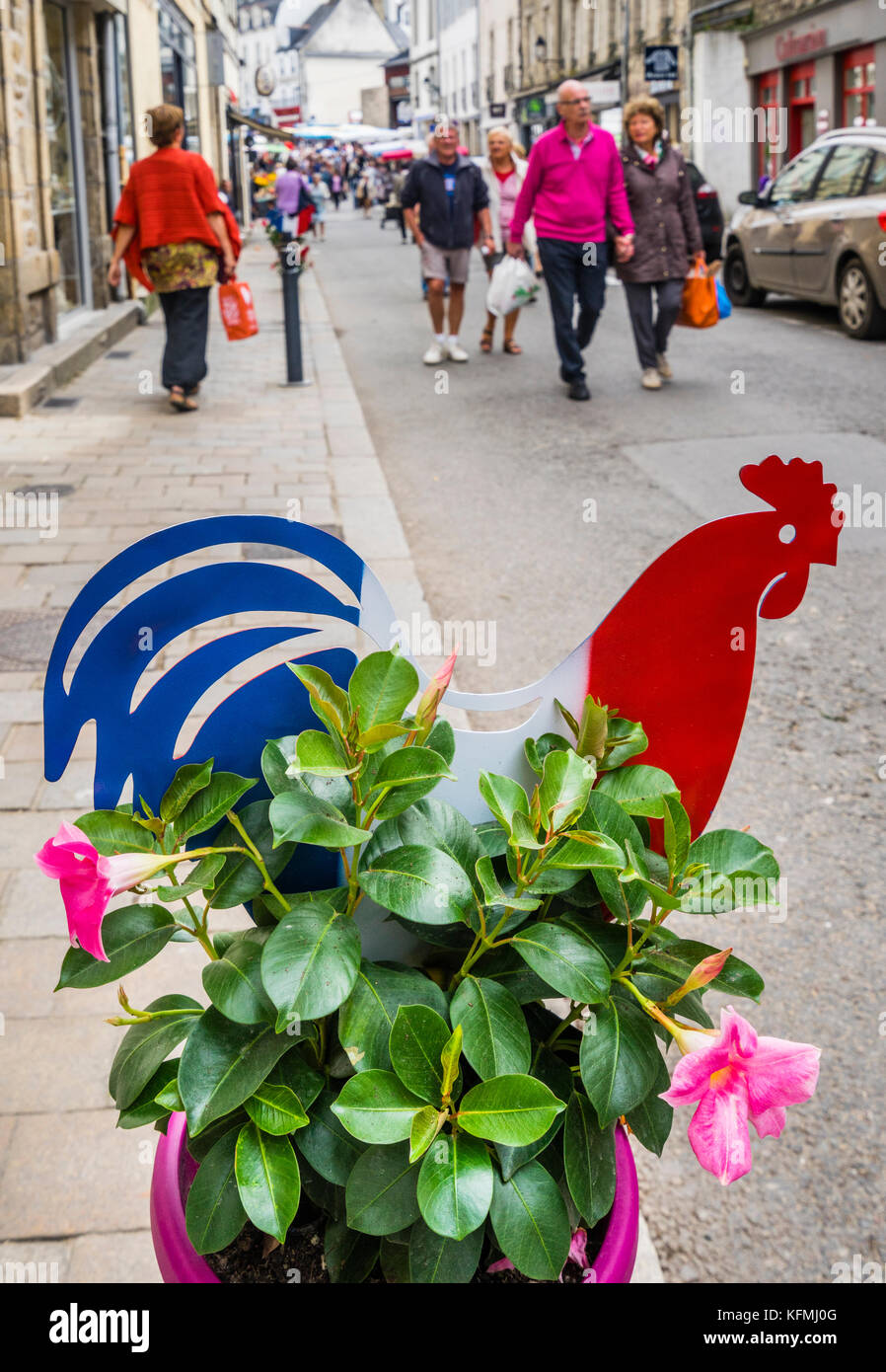Francia, Bretaña, Morbihan, Vannes, un gallo galo decorativamente comparte una olla con petunias en el centro histórico de la ciudad de Vannes Foto de stock