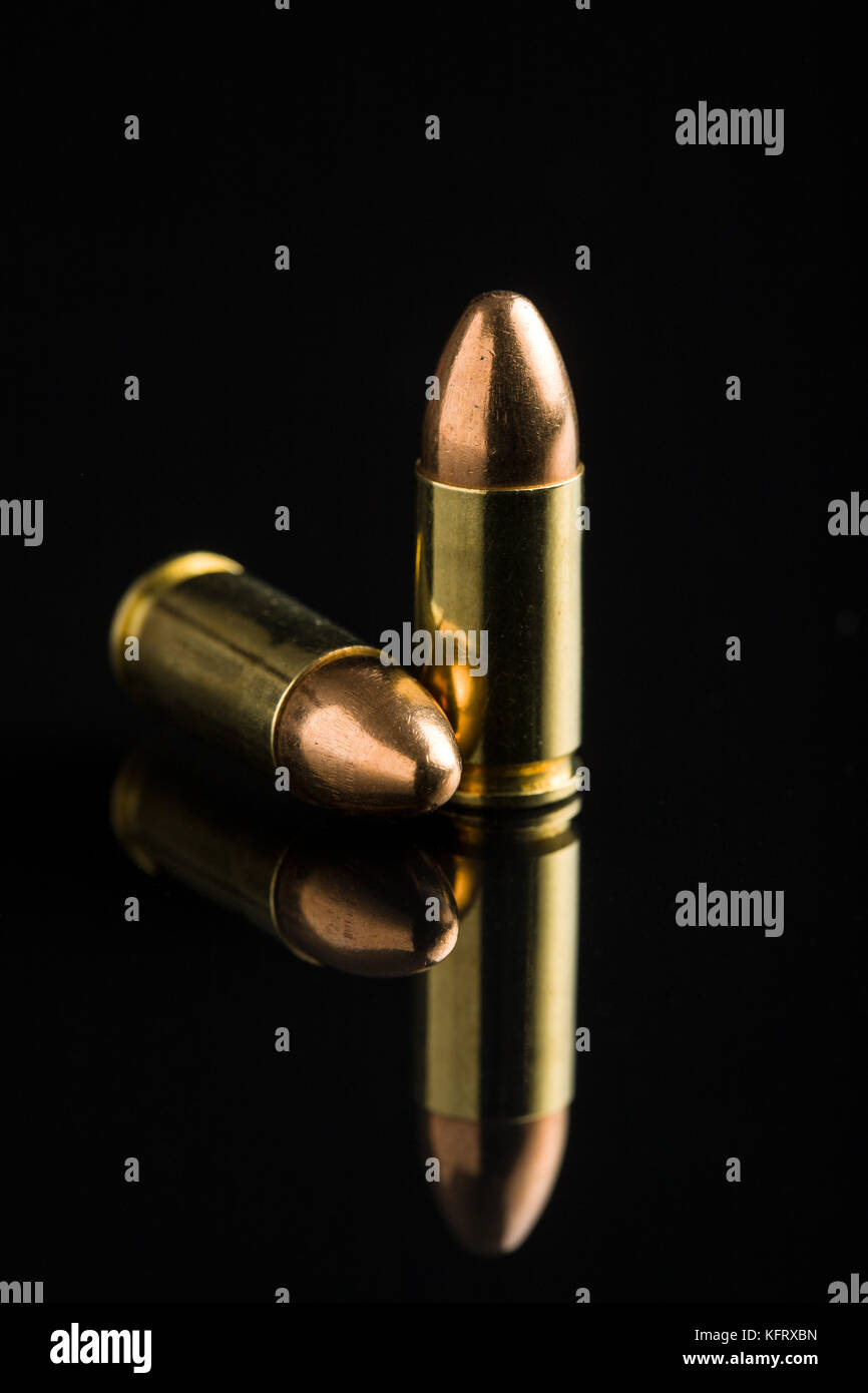 Pistola de 9mm negro balas sobre tabla. Foto de stock