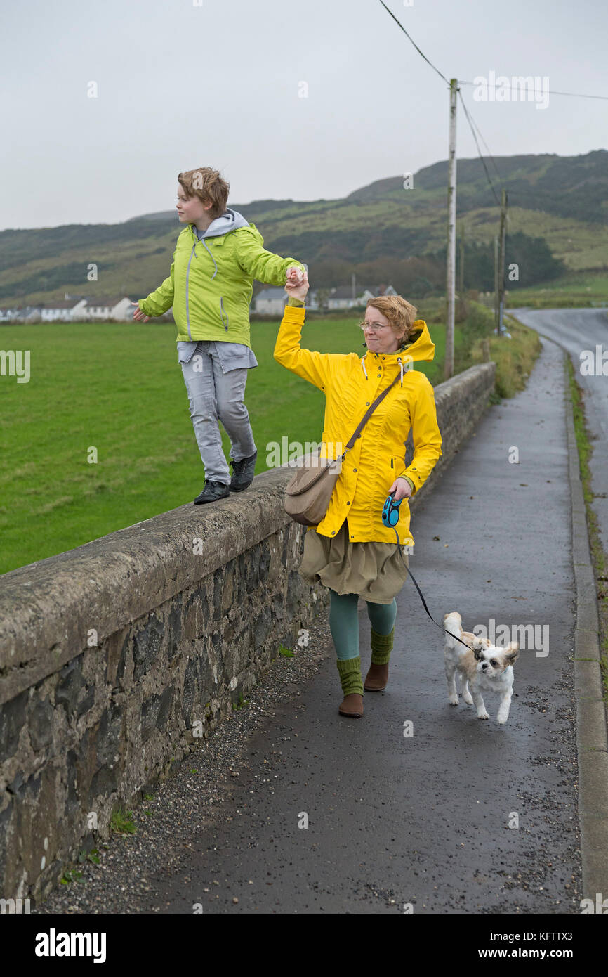 Familia paseando a un perro, Ballintoy, Co. de Antrim, Irlanda del Norte Foto de stock