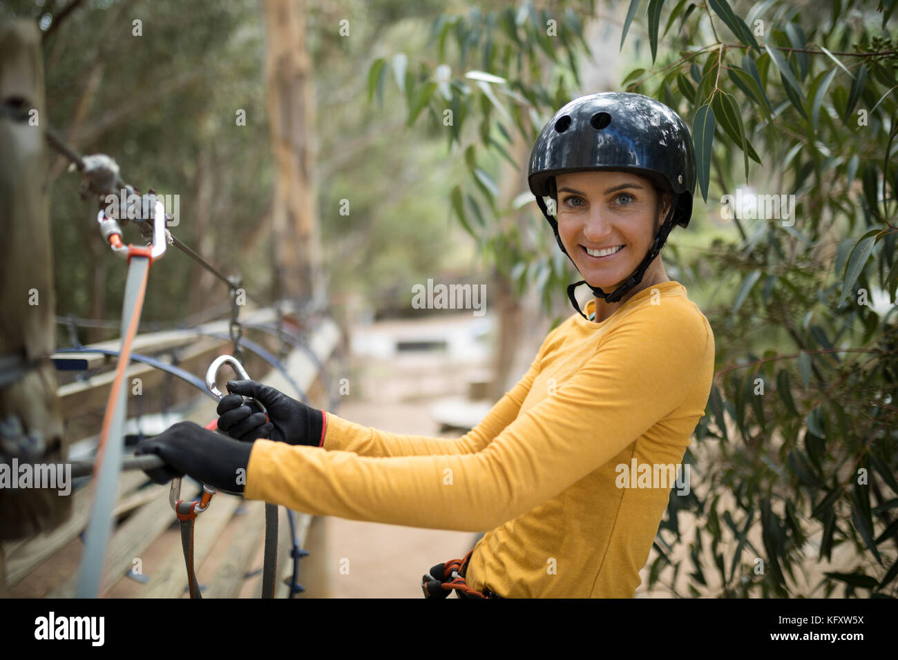 Mujer feliz en tirolesa en el parque de aventura Foto de stock