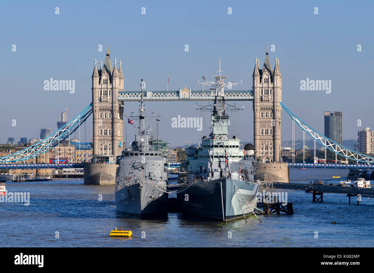 HMS Belfast y Marina de Brasil U27 barco de entrenamiento con el puente de la torre detrás, el Río Támesis, piscina de London, Londres, Reino Unido. Foto de stock
