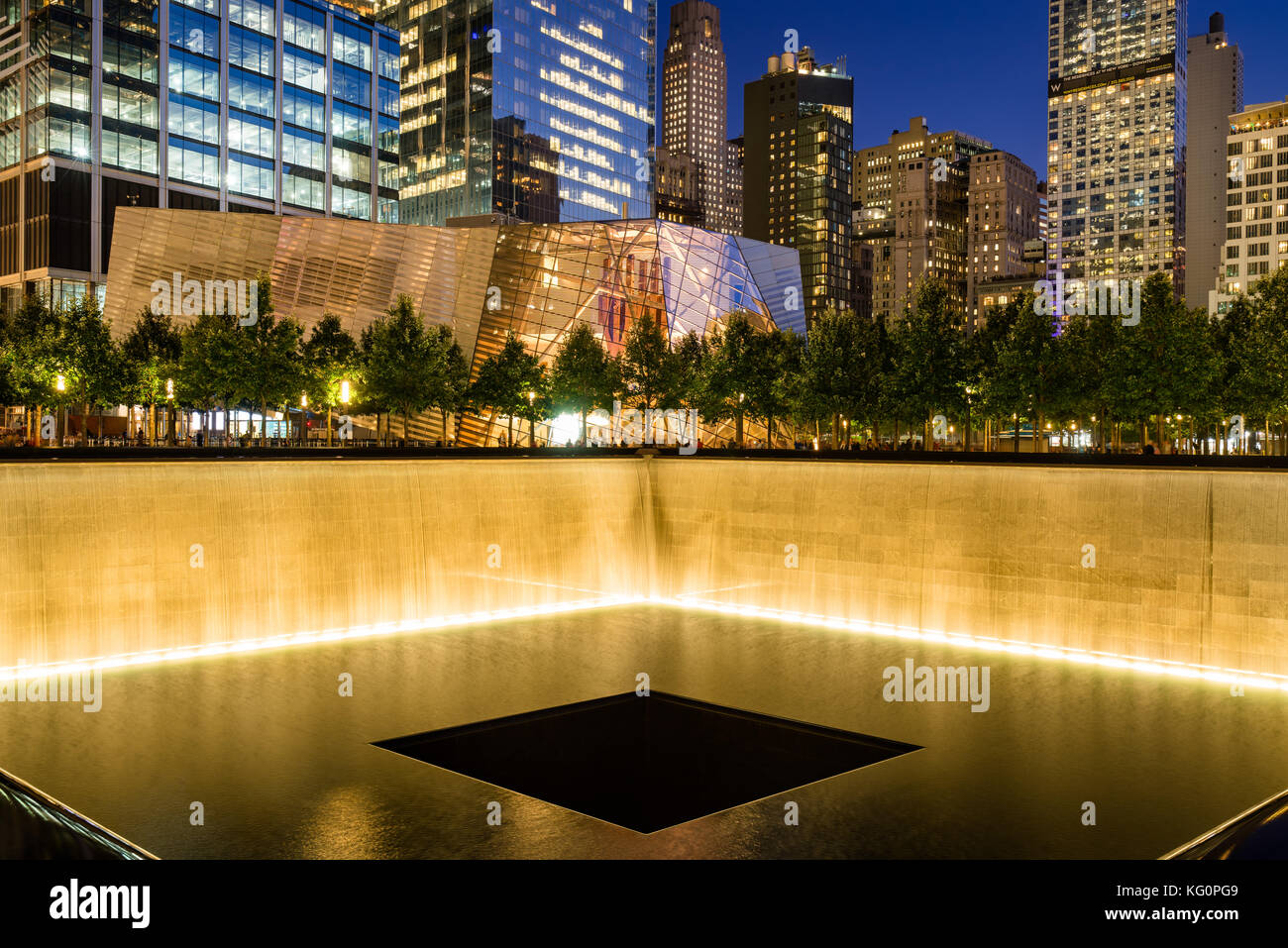 La piscina reflectante del Norte iluminado al atardecer con vista del 9/11 Memorial & Museum. Manhattan, Manhattan, Ciudad de Nueva York Foto de stock