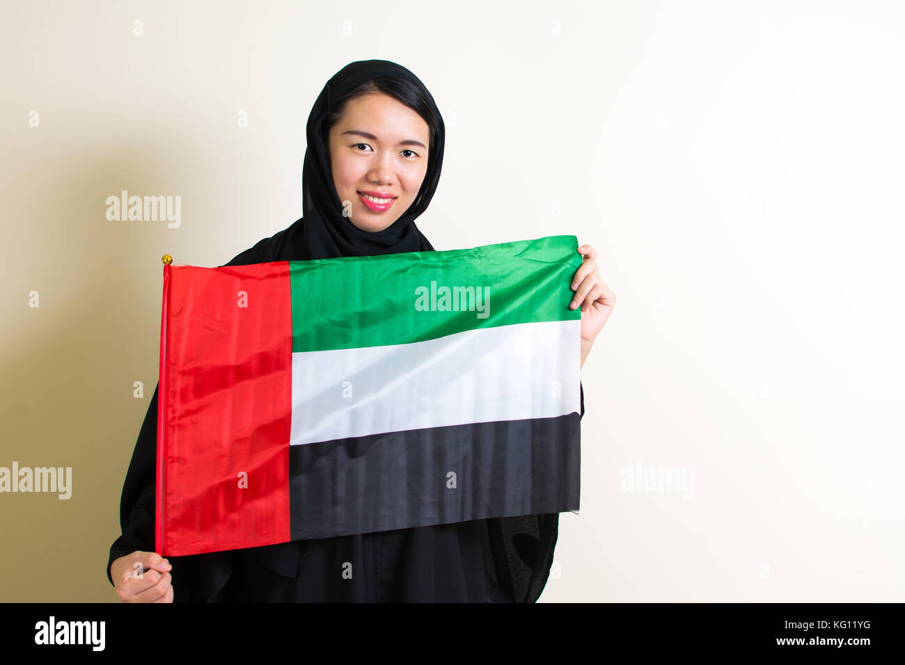 Mujer musulmana, sosteniendo la bandera de los emiratos árabes unidos Foto de stock
