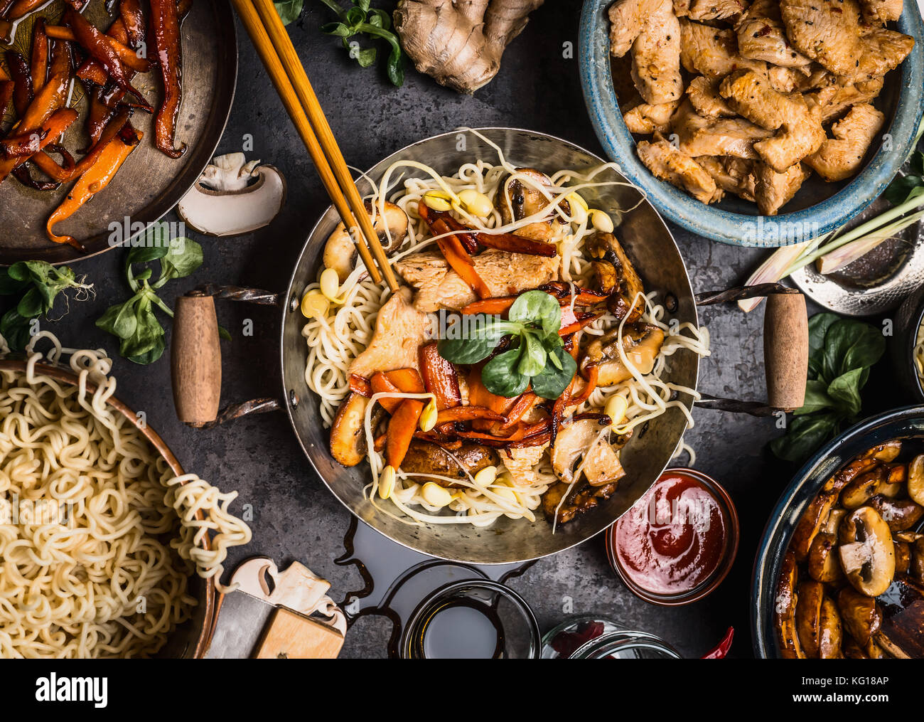 La mesa de la cocina asiática con los recipientes de comida, wok , stir fry  , los palillos y los ingredientes en el fondo, vista superior Fotografía de  stock - Alamy