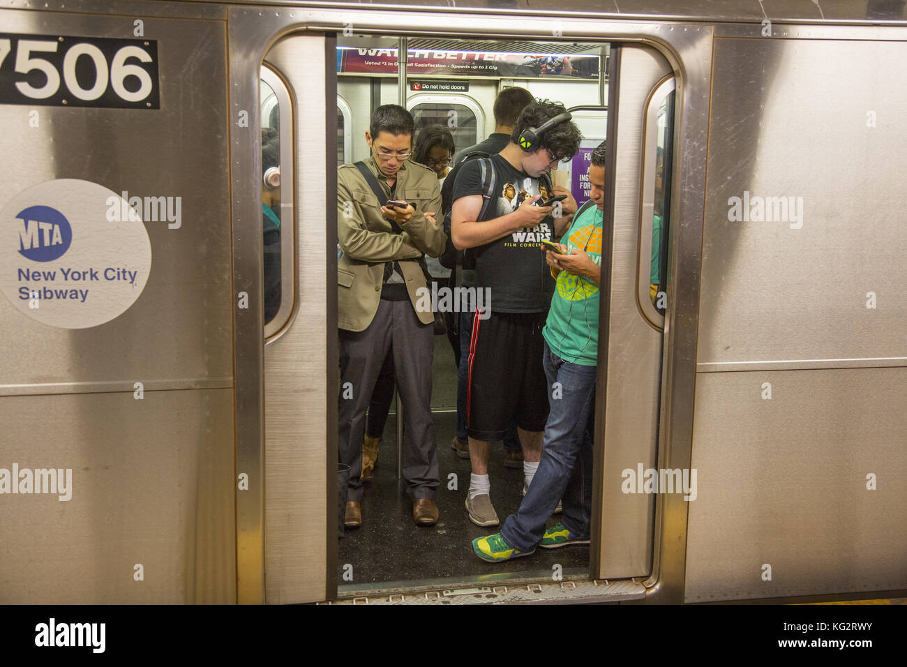 Los hombres jóvenes usan sus teléfonos celulares mientras el tren en la  estación de metro de la calle 42 , como todas las estaciones están  equipadas con acceso gratuito a internet wifi.