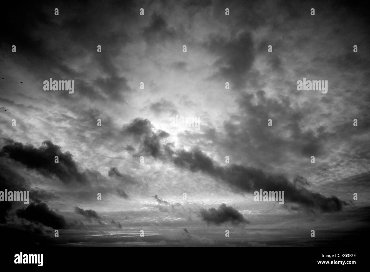 Un oscuro cielo nublado oscurece el fading sun desde la costa atlántica Foto de stock