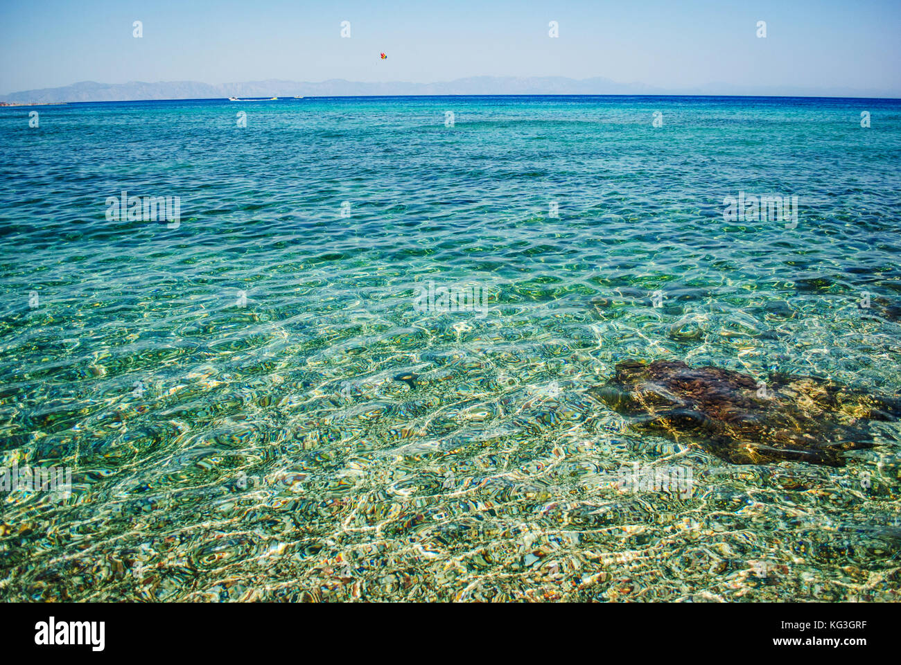 Mar azul y afiladas rocas que lo rodean Foto de stock