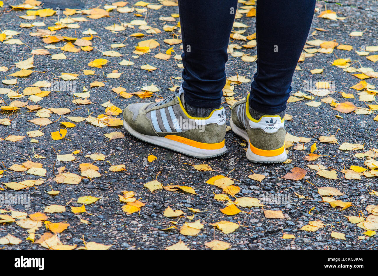 Minsk, Bielorrusia - Octubre 14, zapatos adidas en las piernas sobre el asfalto húmedo alrededor del caído hojas de otoño Fotografía de stock - Alamy