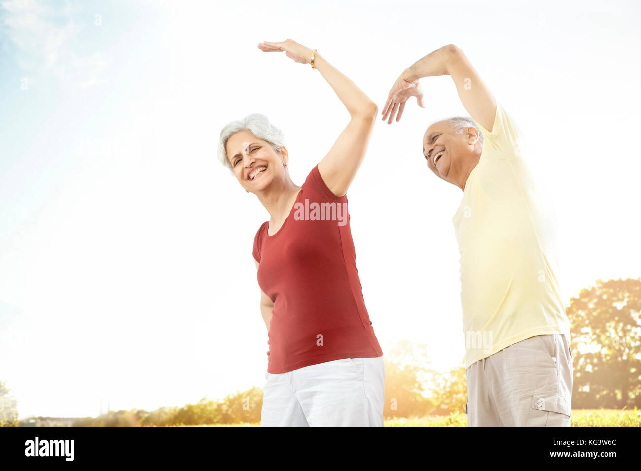 Las parejas ancianas haciendo ejercicio de estiramiento en el parque al aire libre Foto de stock