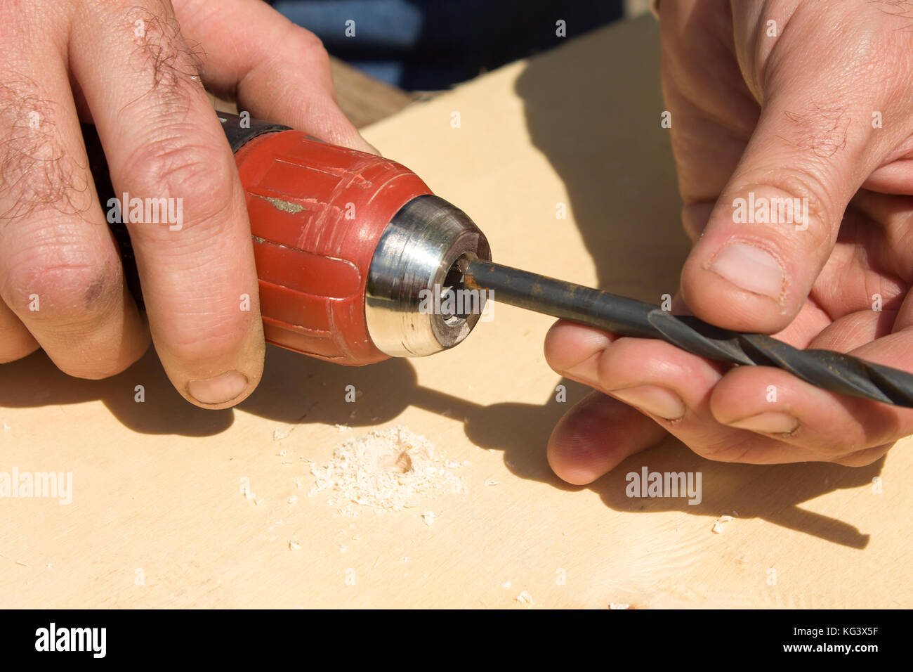 Las manos del carpintero adjuntar un taladro en la cabeza de la broca  Fotografía de stock - Alamy
