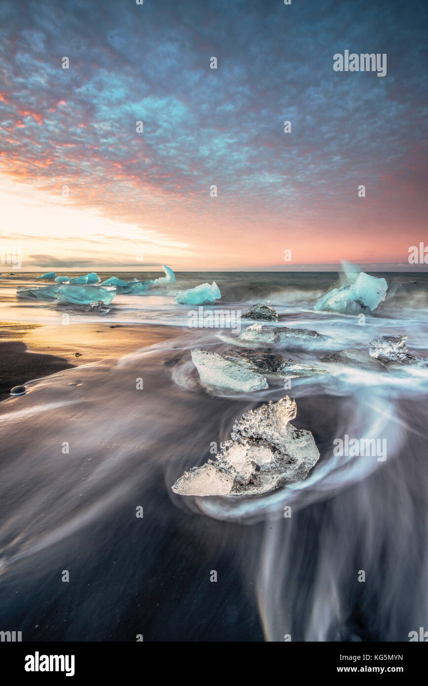 La Laguna glaciar Jokulsarlon, el este de Islandia. Bloques de hielo negro en la playa al amanecer. Foto de stock