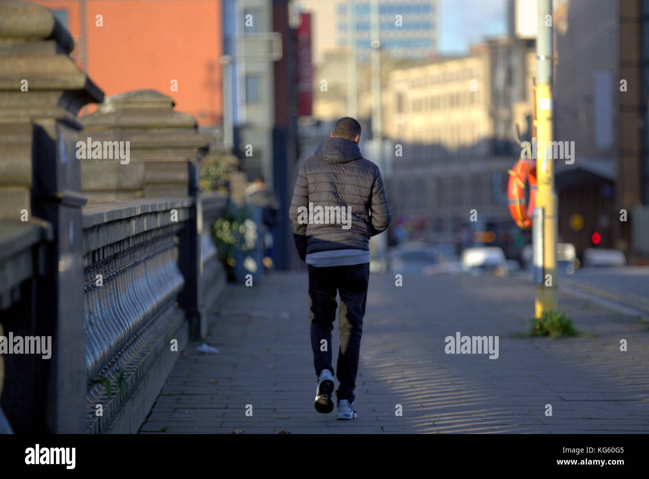 Hombre negro caminando por la calle bridge visto desde atrás Foto de stock