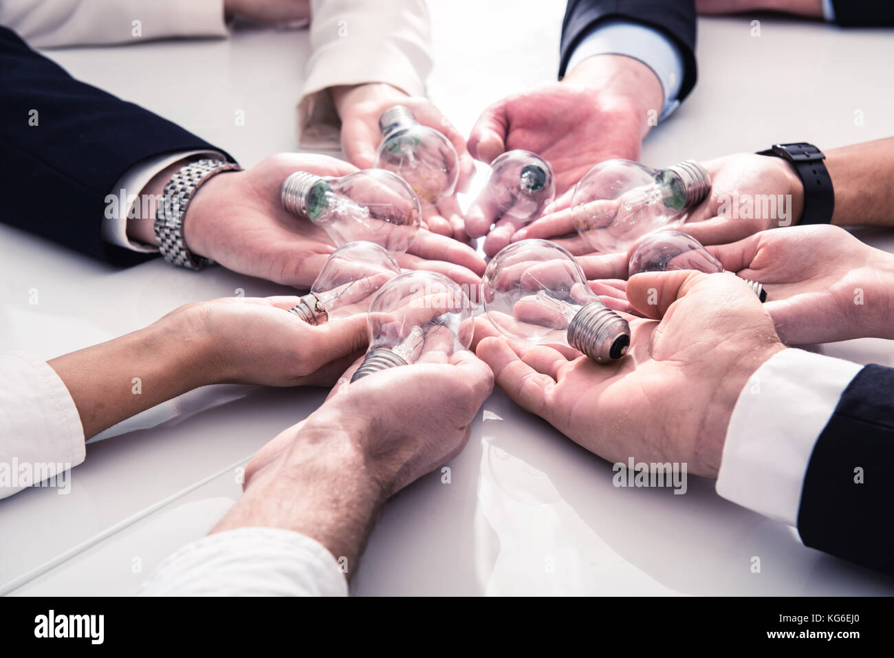 El trabajo en equipo y el concepto de lluvia de ideas con empresarios que comparten una idea con una lámpara. Concepto de inicio Foto de stock