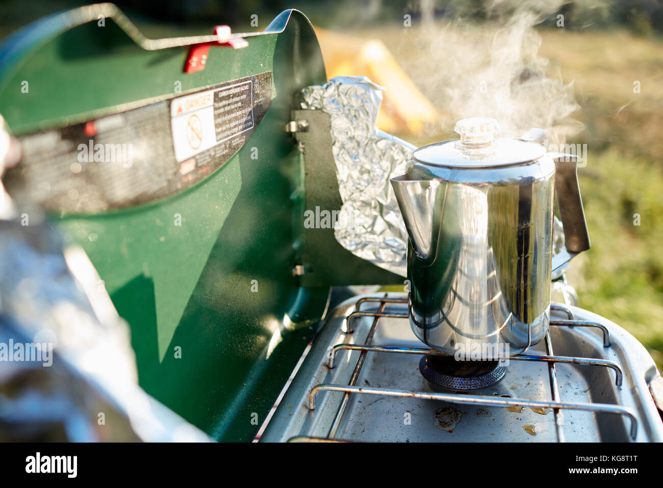 Calentar agua para café en un quemador de gas en una humeante olla de acero  inoxidable mientras acampar al aire libre Fotografía de stock - Alamy