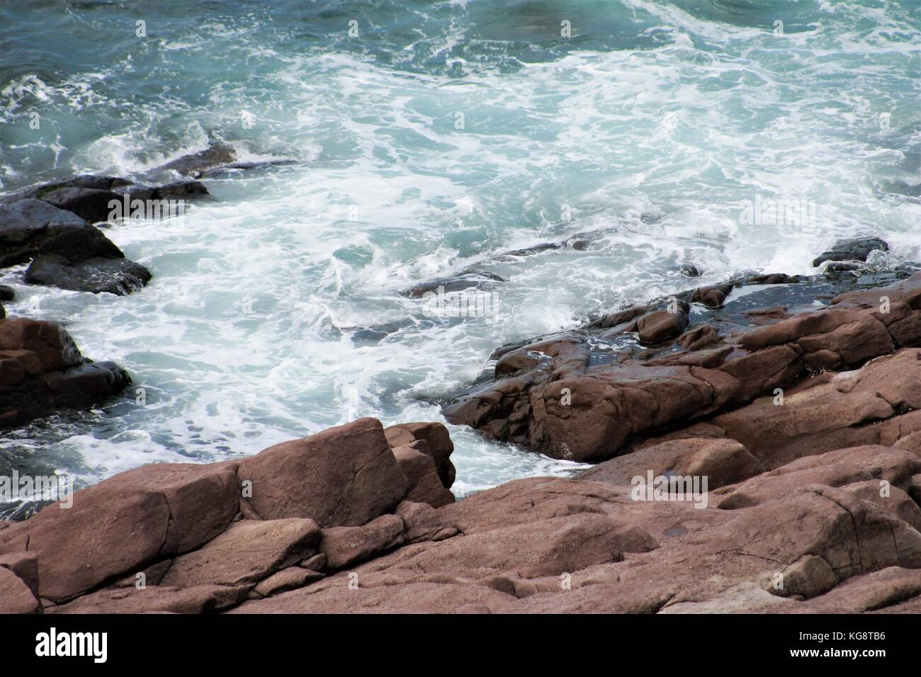 Las olas rompiendo contra las rocas, Cabo Spear, Terranova. Un litoral accidentado, agua blanca. Foto de stock