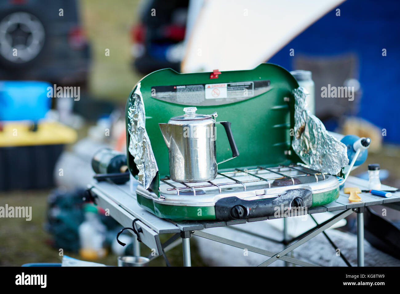 Acero inoxidable cafetera calefacción en un pequeño camping gas grabadora  portátil configurado al aire libre sobre una mesa plegable mientras prepara  el desayuno Fotografía de stock - Alamy