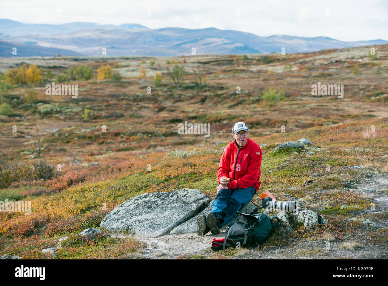 Trekker tomando un descanso en las montañas noruegas. Dobre, Noruega. Foto de stock