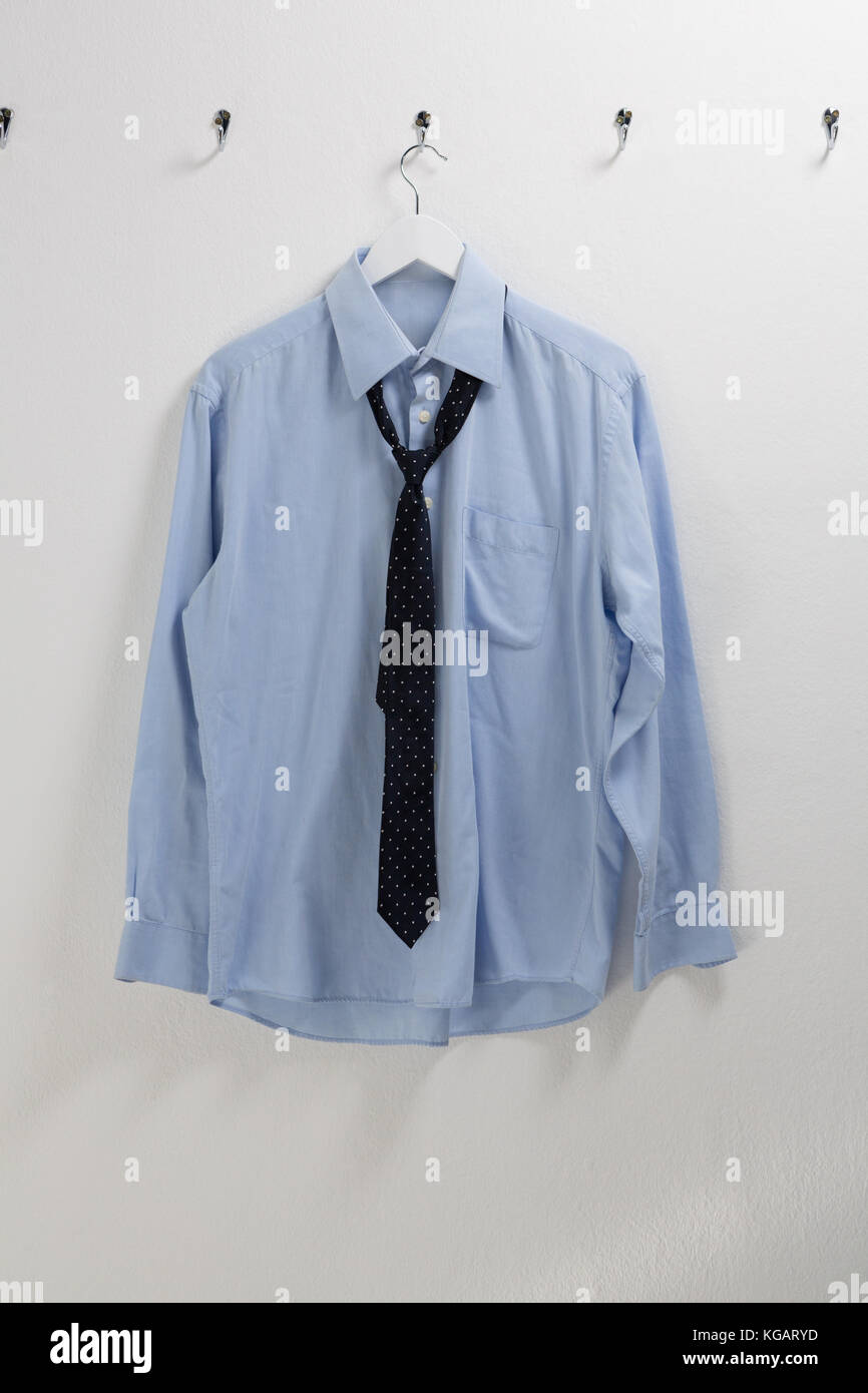 Impulso Suposición viudo Camiseta con corbata colgando en el gancho contra la pared Fotografía de  stock - Alamy