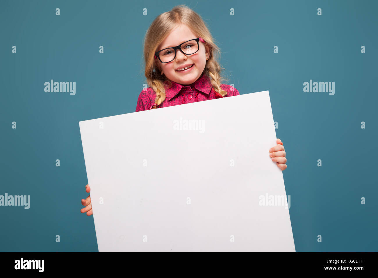Adorable niña en camisa rosa, pantalones negros y gafas tiene cartel vacío  Fotografía de stock - Alamy