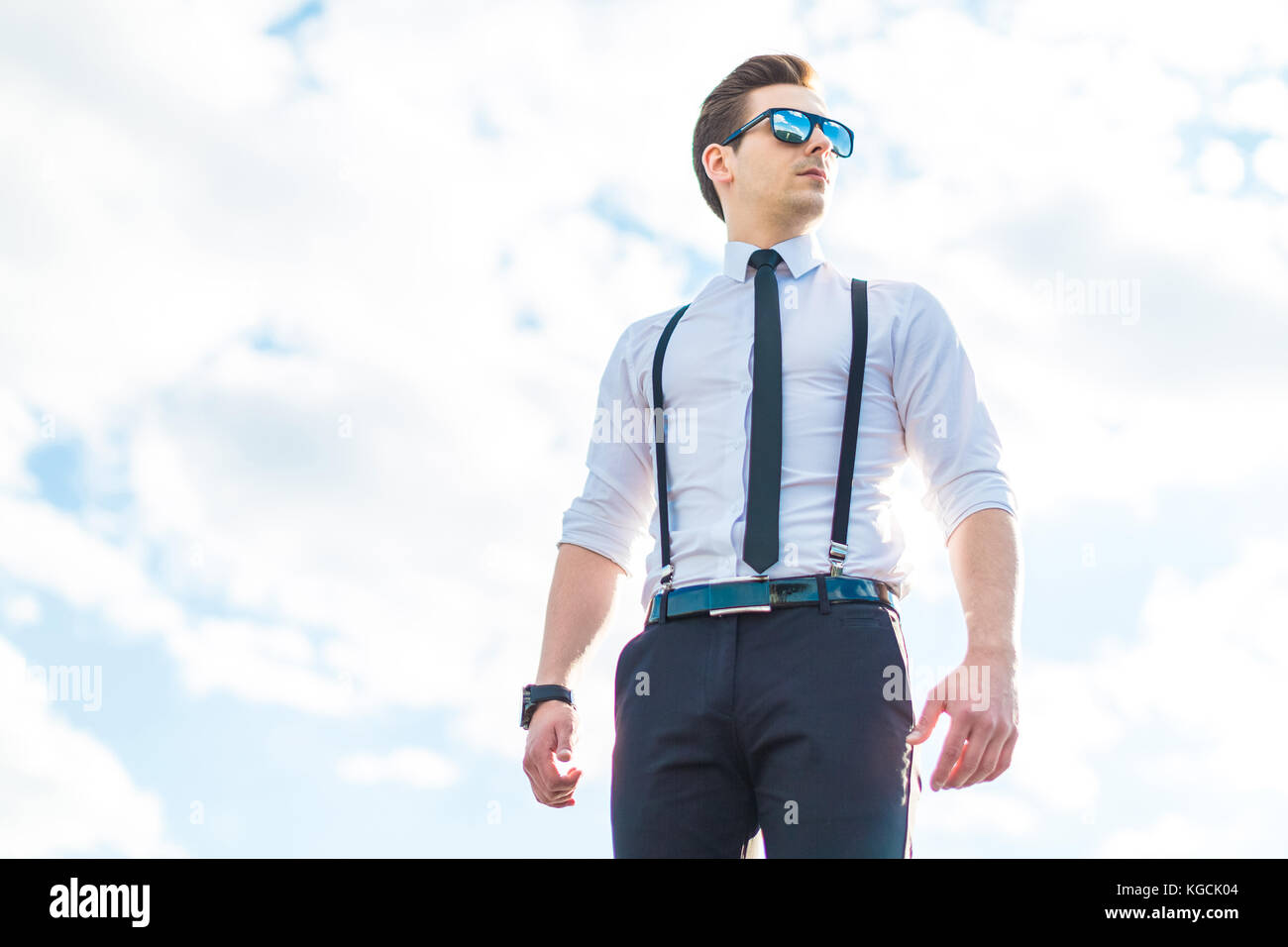 Grave busunessman joven con la camisa blanca, corbata, tirantes y sungla  Fotografía de stock - Alamy