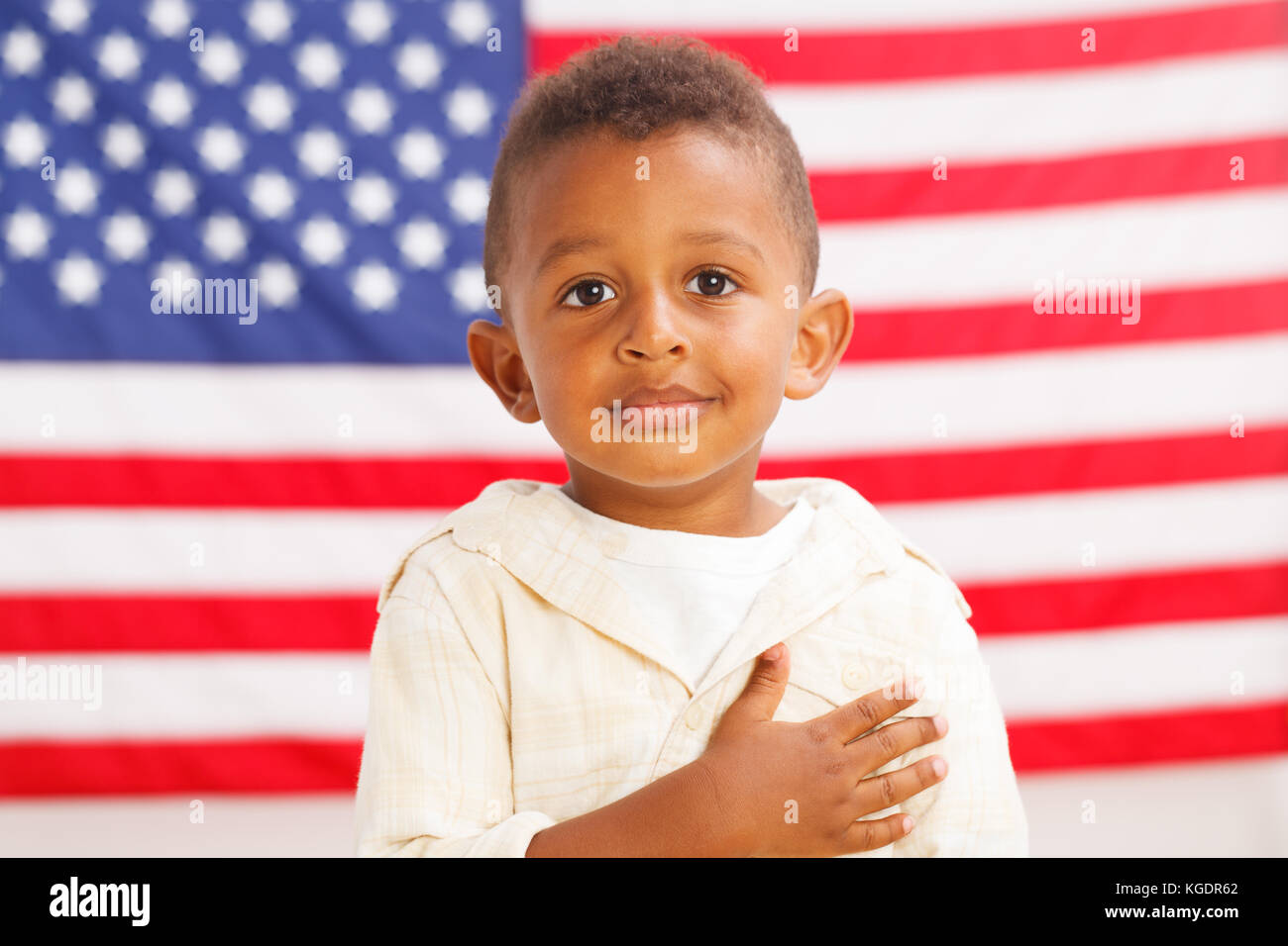 Niñito africano-americanos con bandera americana sobre un fondo Foto de stock