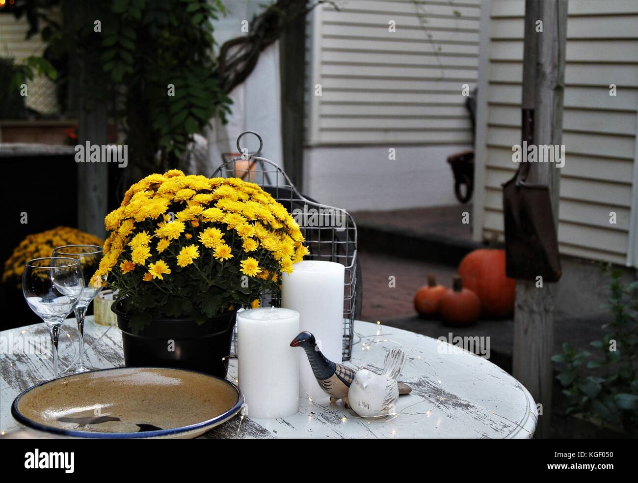 Mostrar tabla caída decorado con velas, cerámica, copas de vino, el crisantemo planta Foto de stock