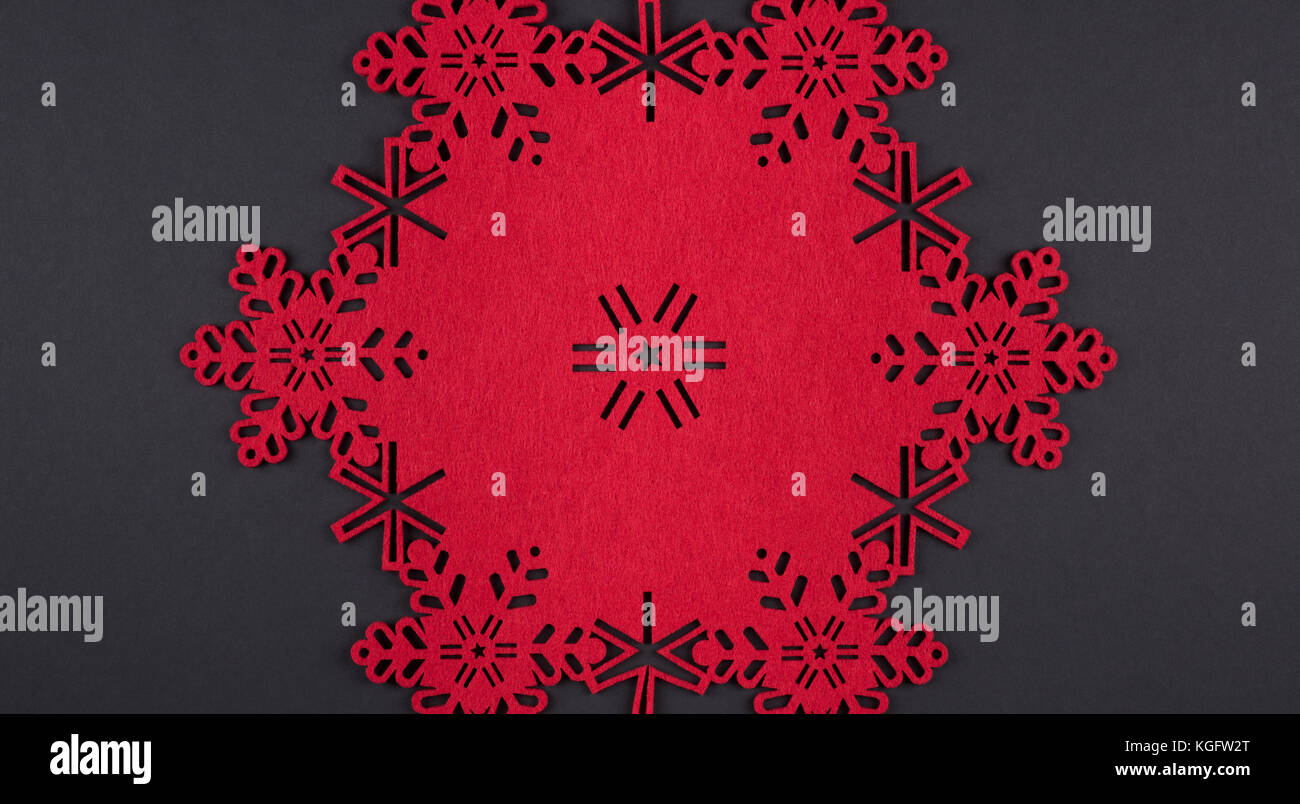 Diseño inusual de fondo de navidad con copos de nieve roja y copie el espacio sobre fondo gris oscuro Foto de stock