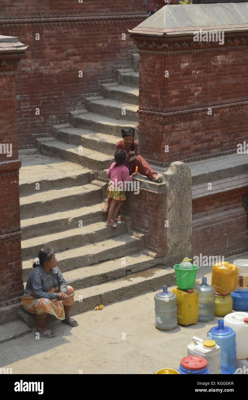 Gente nepalesa esperando para recoger agua potable con jerrycan en una fuente antigua, Katmandú, Nepal. escasez de agua, sequía, después del terremoto Foto de stock