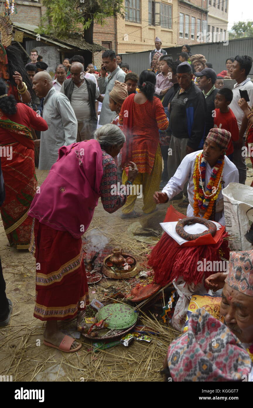 Vieja mujer nepalesa ofreciendo a los dioses durante el festival de jatra en Panauti, Nepal. Los dioses vienen a la pequeña aldea durante un festival de 3 días. humo de incentivo. Foto de stock