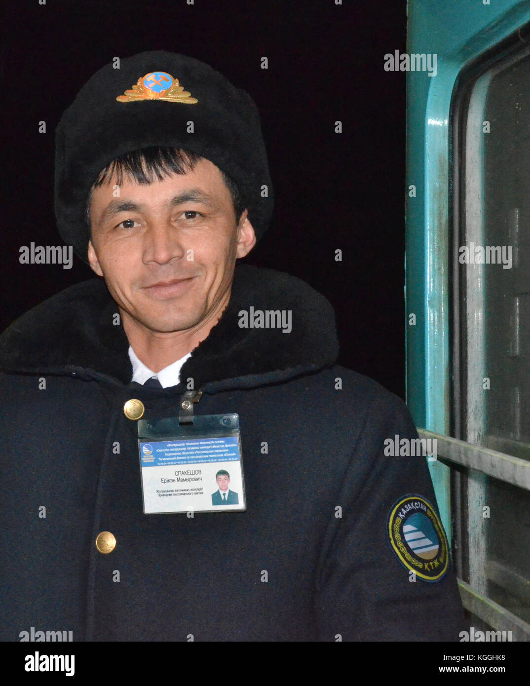 Conductor de tren kazajo, prodvodnik, con diente dorado y sombrero de piel de ushanka. Tren en Kazajstán durante el invierno. Hielo frío. -13 grados fahrenheit, -25 grados centígrados. Foto de stock