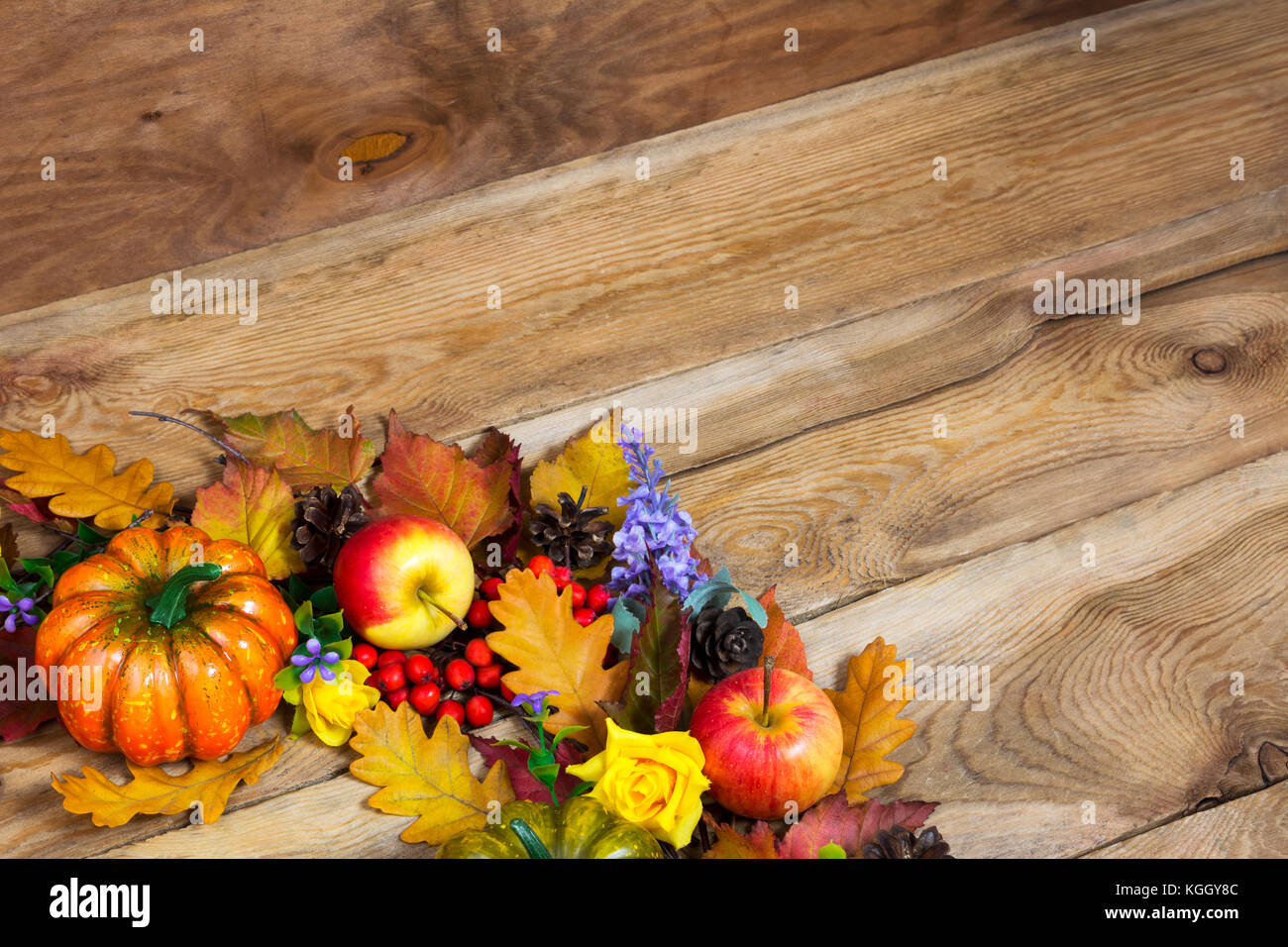 Caída saludo con fondo rosa amarilla, hojas de roble, calabaza, manzana, lila flores y bayas de serbal rojo, espacio de copia Foto de stock