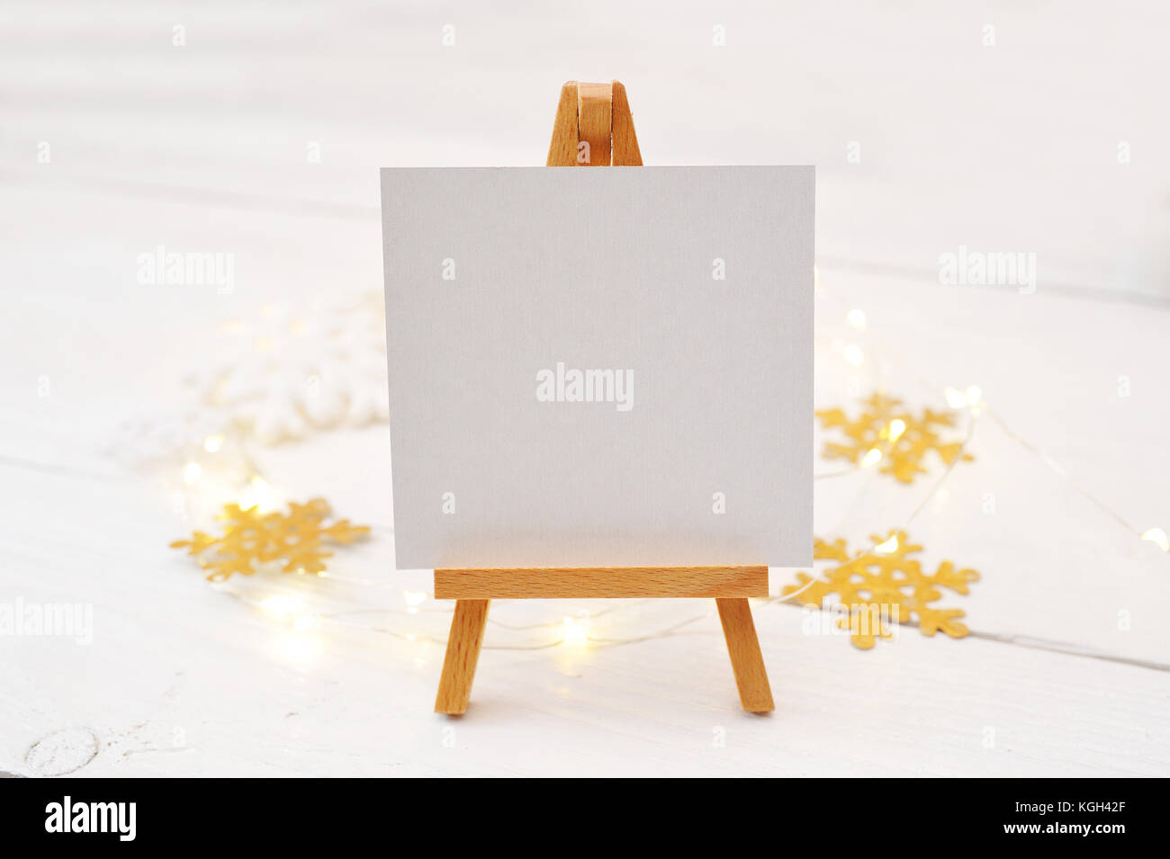 Caballete en miniatura con tarjeta en blanco, ramas de pino y decoraciones de Navidad. Espacio para el texto. top view photo boceto Foto de stock