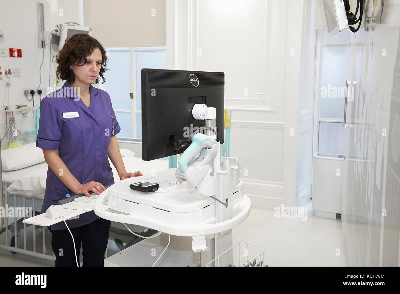 Una enfermera la comprobación de la información de un ordenador en un hospital. Foto de stock