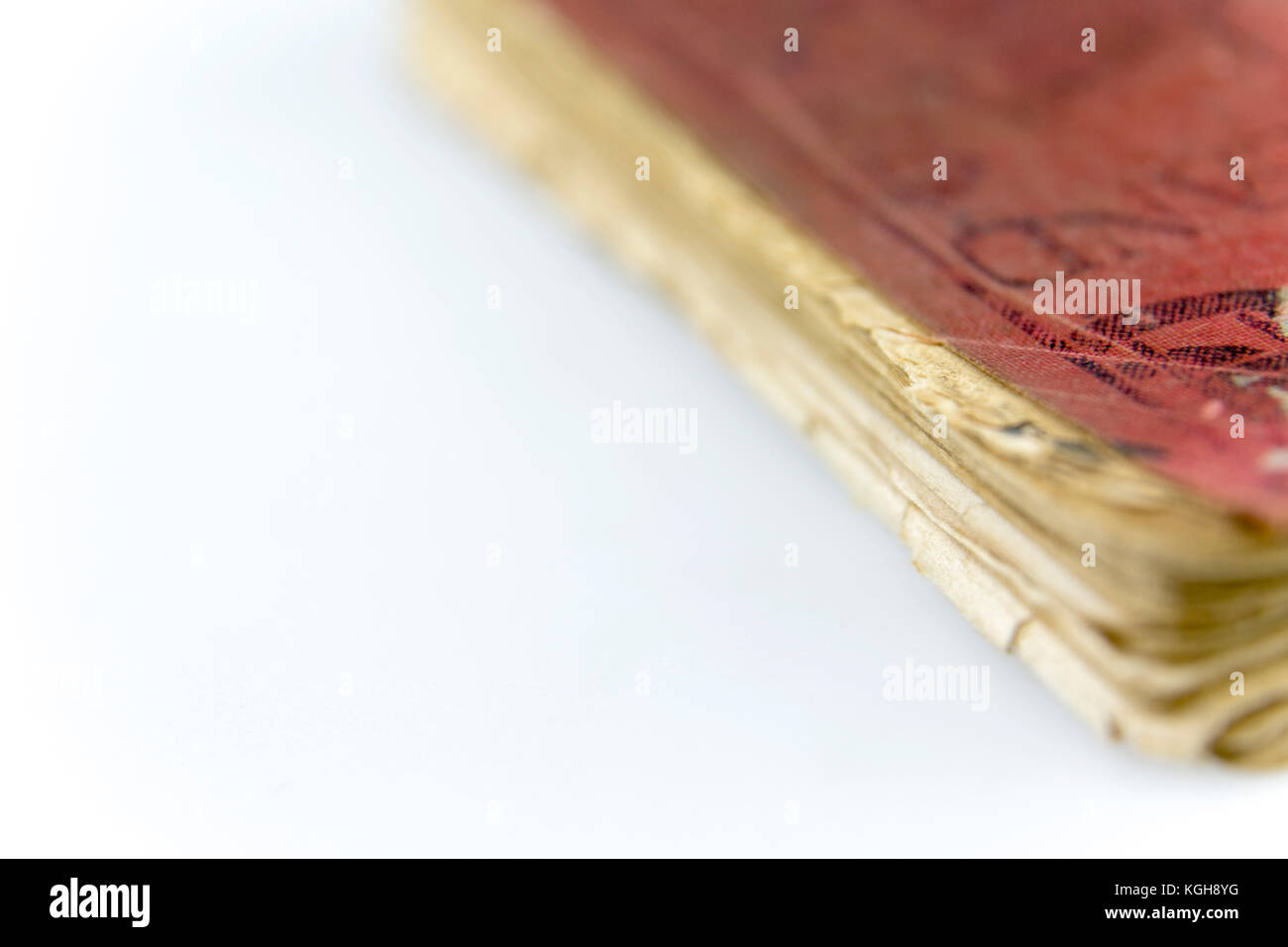 Casco antiguo libro desgastado con el desgaste de los bordes de la página doblada y manchada roja cubierta en blanco. vintage publicación impresa. Foto de stock