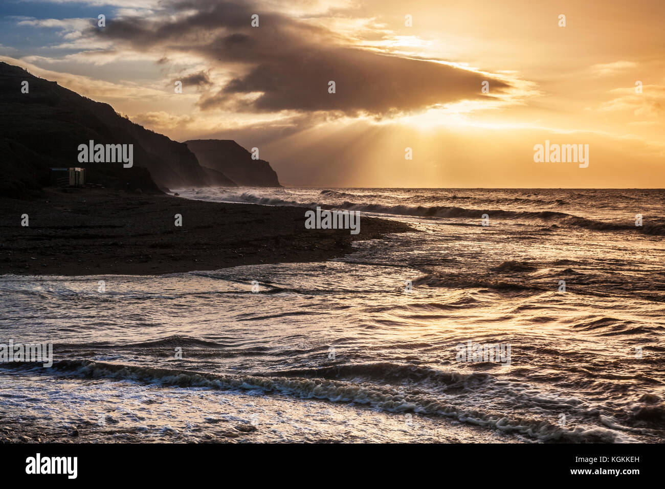Amanecer en playa Charmouth mirando hacia la tapa de oro. Foto de stock