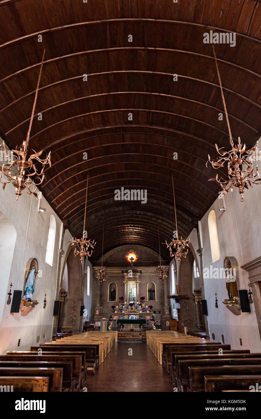 Interior de la iglesia del Templo de nuestra Señora del Sagrario con techo  de madera de barril y candelabros de cobre en Santa Clara del Cobre,  Michoacán, México Fotografía de stock -