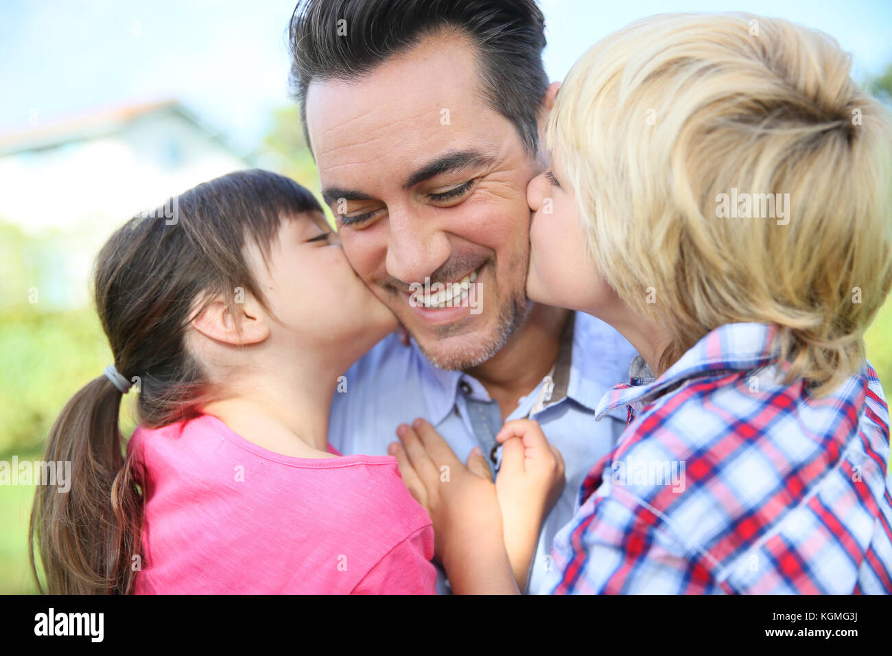 Retrato de los niños dándole un beso a su papá Fotografía de stock - Alamy