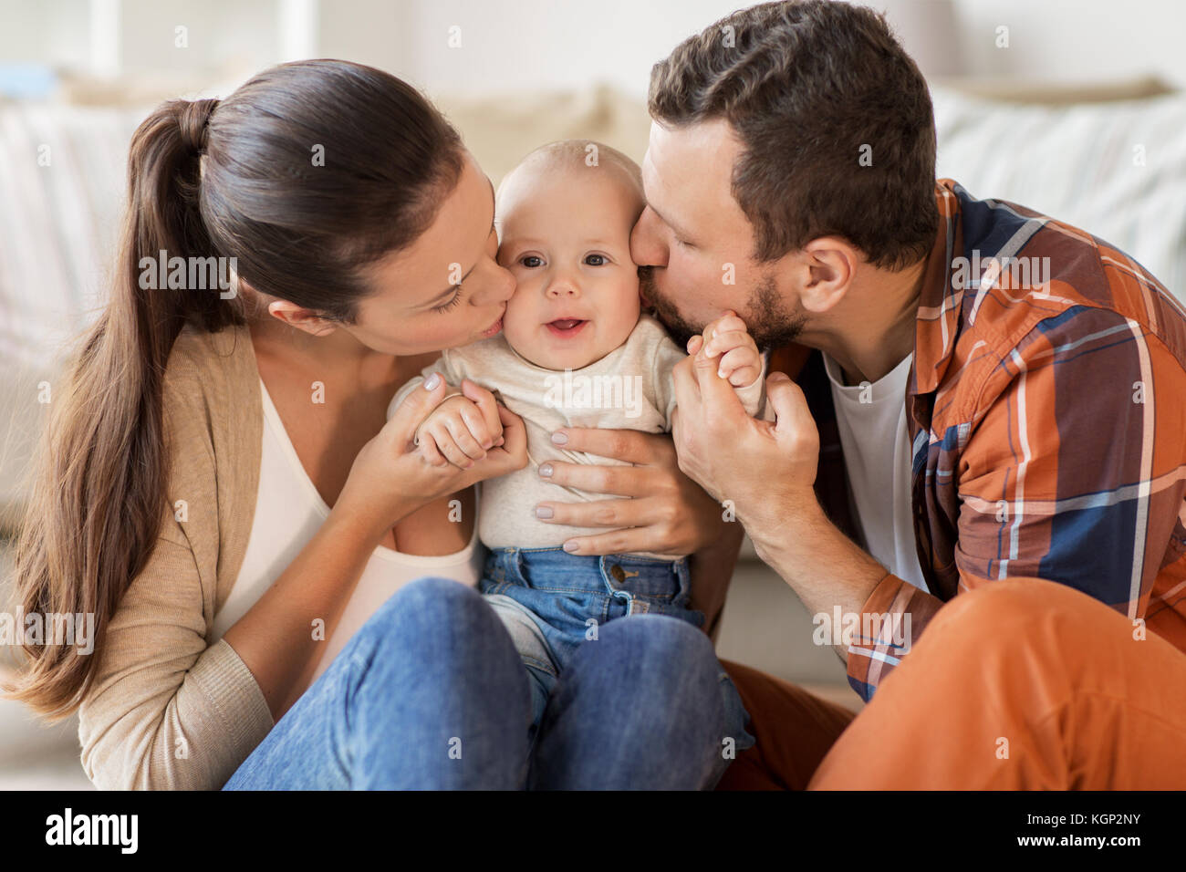 Feliz Madre Y Padre Besar A Bebe En El Hogar Fotografia De Stock Alamy