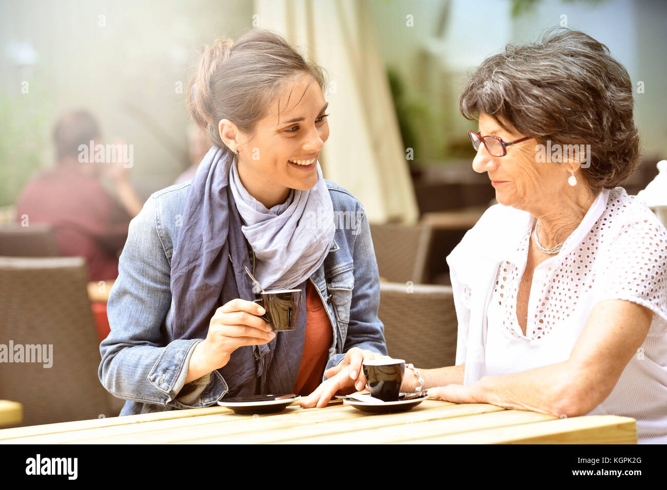 Mujer mayor con cuidador en casa tomando café juntos Foto de stock