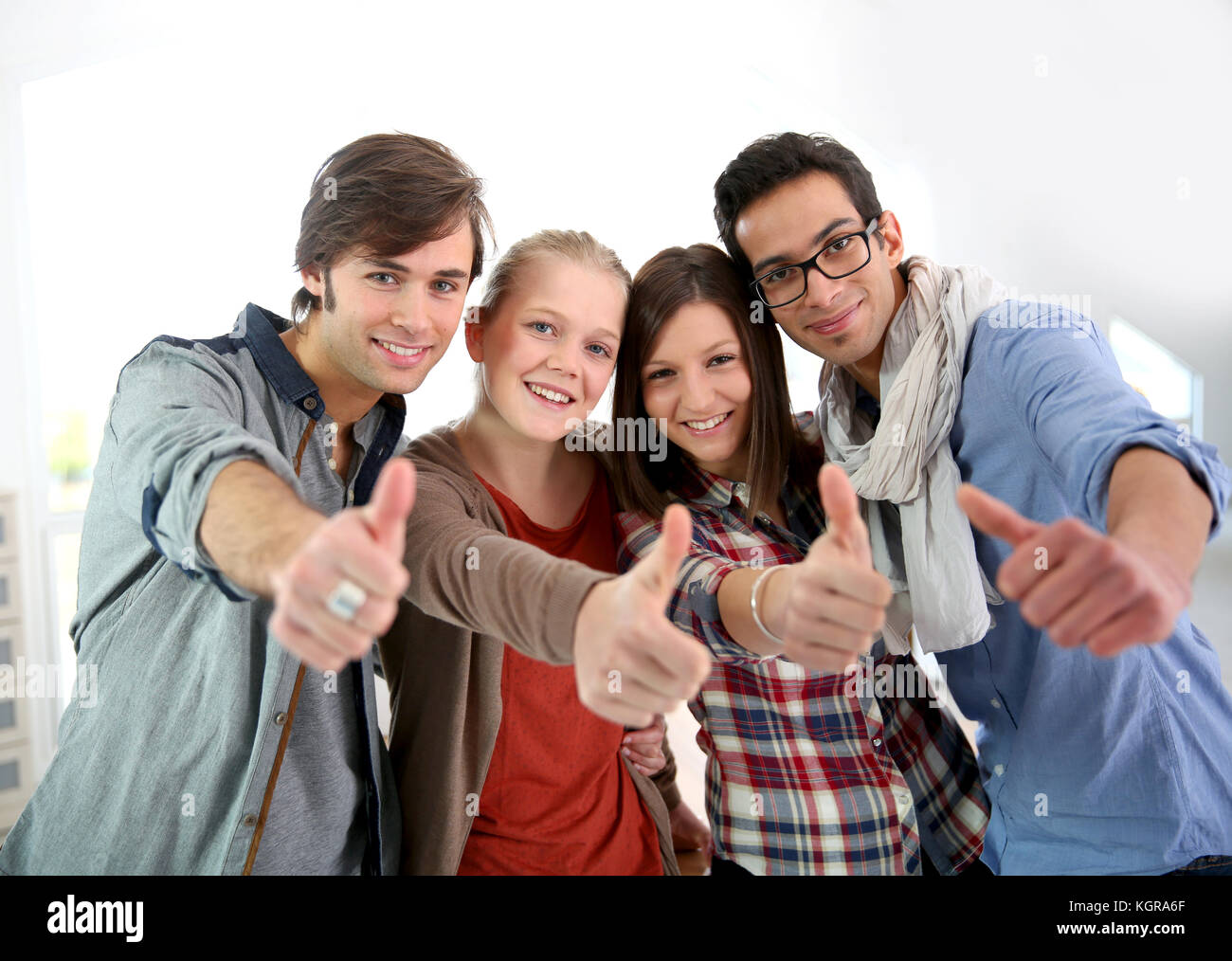 Grupo de estudiantes alegres mostrando Thumbs up Foto de stock