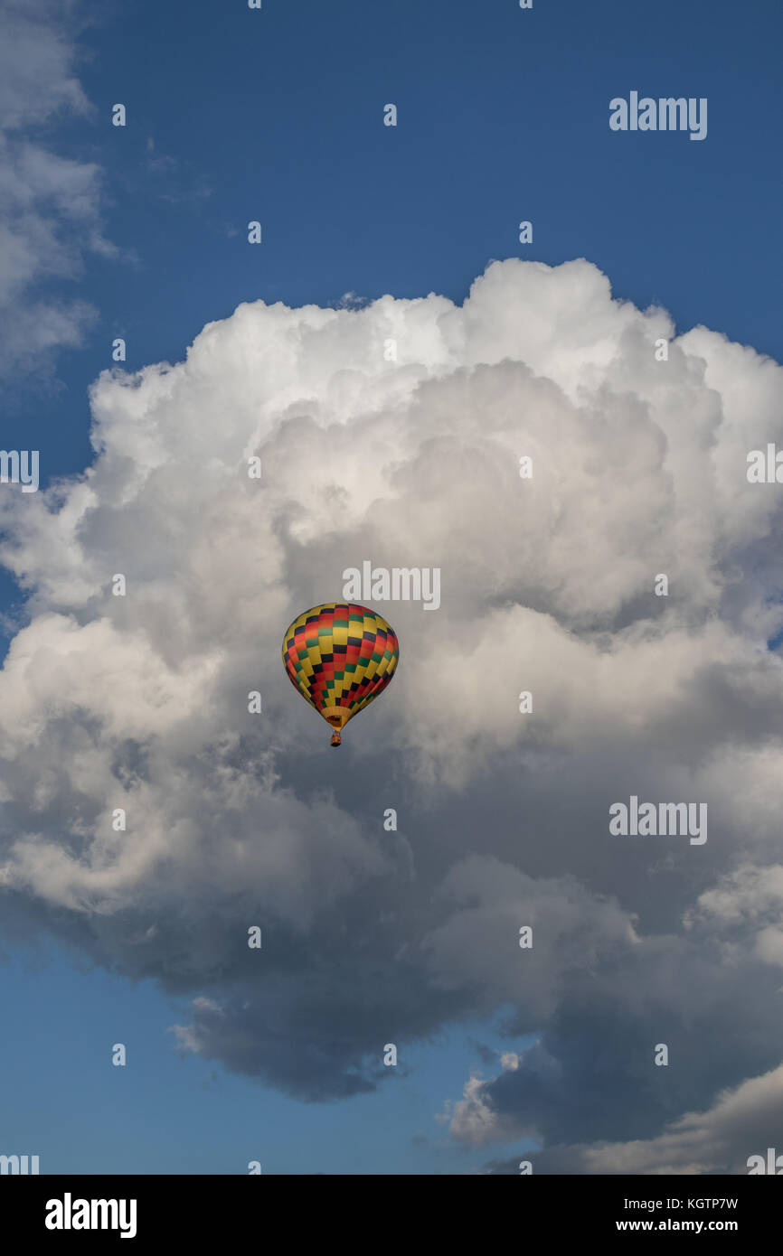 Colorido globo de aire caliente con nubes hinchadas en segundo plano. Foto de stock