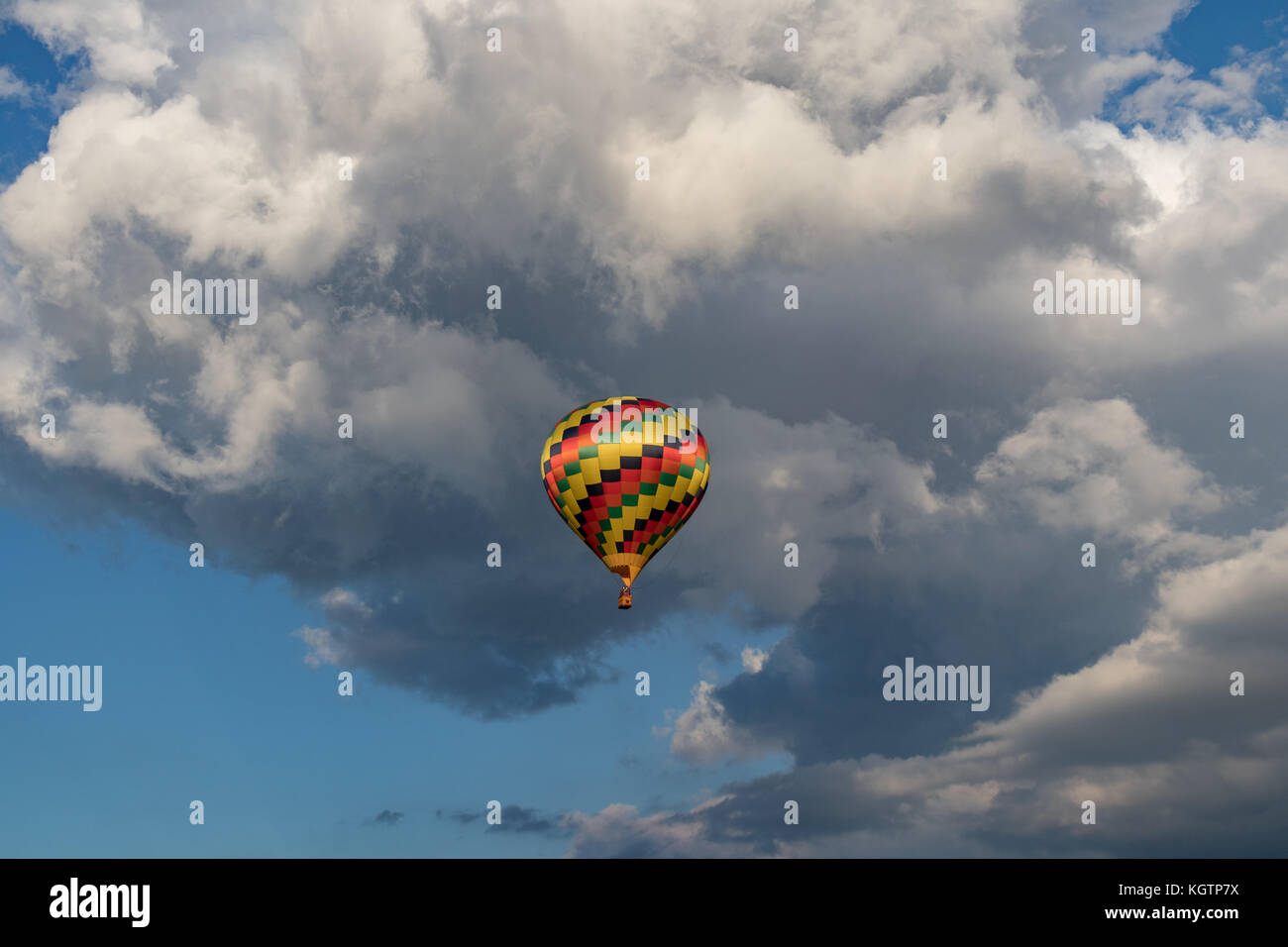 Colorido globo de aire caliente con nubes hinchadas en segundo plano. Foto de stock