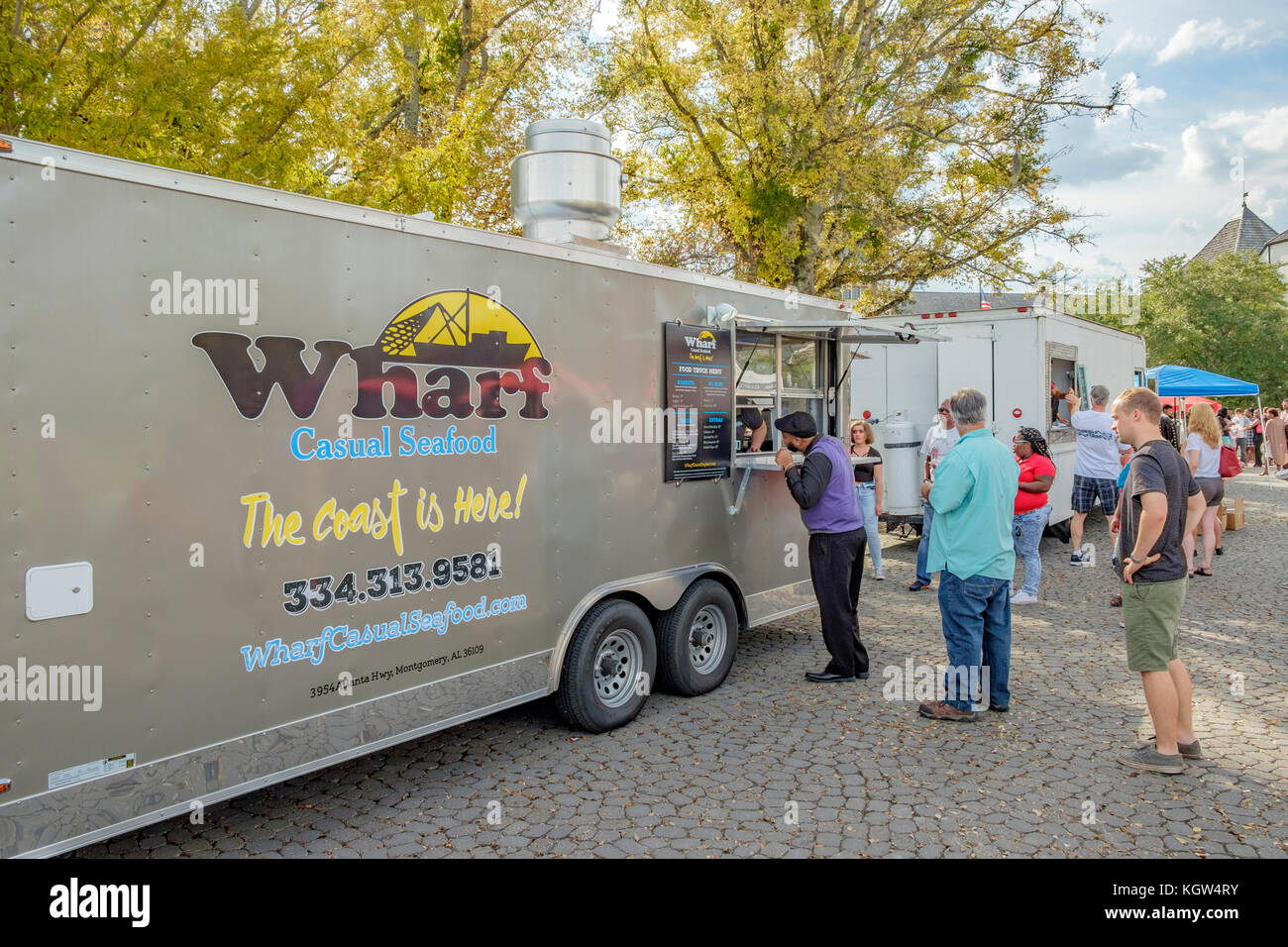 Los clientes con un camión de alimentos festival en una pequeña comunidad en Montgomery, Alabama, EE.UU., espere en línea o cola para pedir comida. Foto de stock