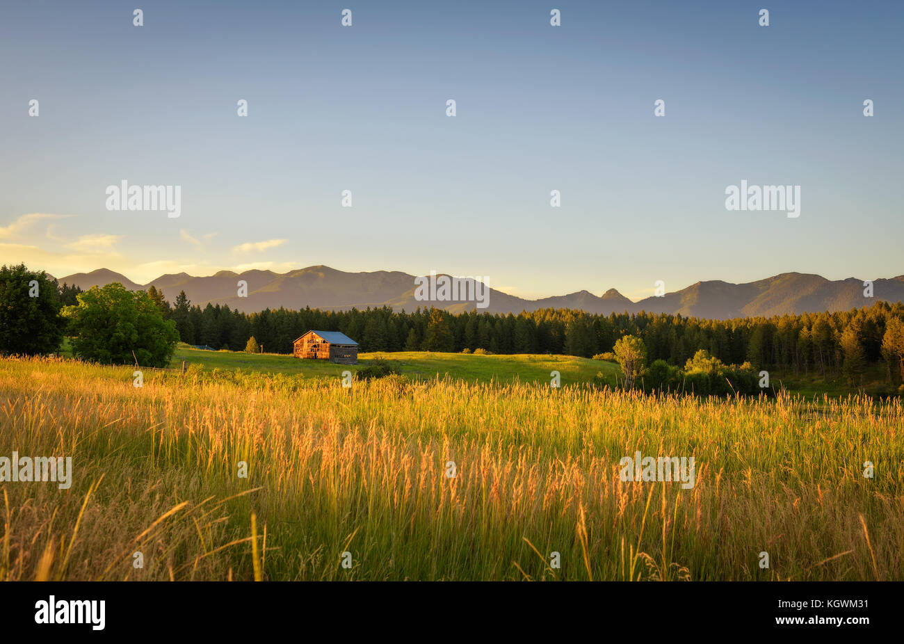Atardecer de verano con un viejo granero en la zona rural de montana Foto de stock